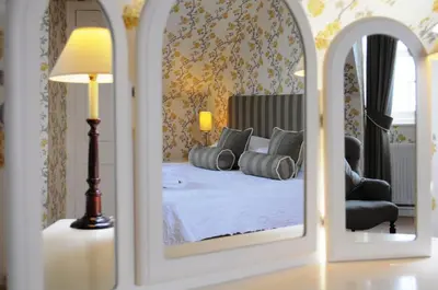 a mirror reflection of a bed in a bedroom at The Creggans Inn in Strachur