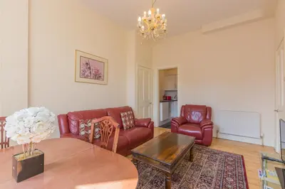 a living room with red furniture and a table at Menzies Apartments in Edinburgh