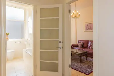 a bathroom with a living room with a couch at Menzies Apartments in Edinburgh