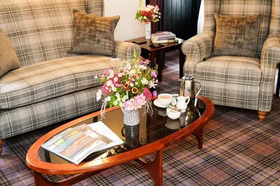 a living room with couches and a table with flowers on it at The Lagg in Lagg