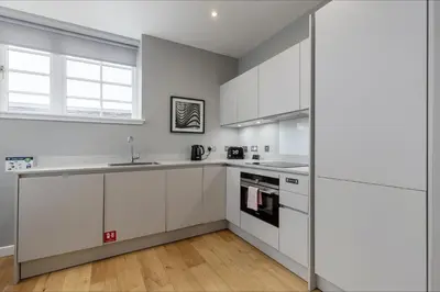 a kitchen with white cabinets and a sink at Destiny Scotland Apartments at Canning Street Lane in Edinburgh