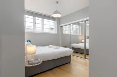 a bedroom with a bed and a table with a lamp at Destiny Scotland Apartments at Canning Street Lane in Edinburgh