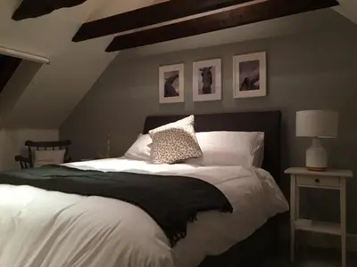 a bedroom with a large bed with a black and white blanket at Leirsinn Mhor in Killin