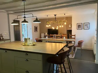 a kitchen with a large island with chairs and a dining room at Leirsinn Mhor in Killin