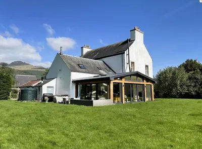 a large white house with a large lawn in front of it at Leirsinn Mhor in Killin