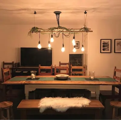 a dining room with a wooden table with lights at Leirsinn Mhor in Killin