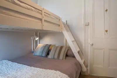 a bedroom with a bunk bed with a ladder at Country Nest in Carnwath