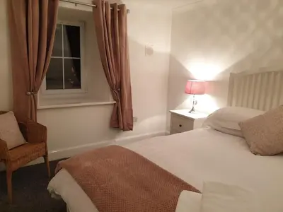 a bedroom with a bed and a chair and a window at The Old School in Salen