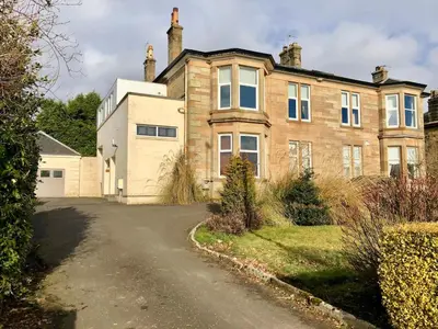 a large brick house with a driveway at A Spacious Flat with Character - Private Car Space in Paisley