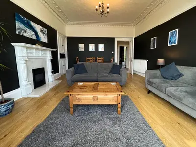 a living room with two couches and a coffee table at A Spacious Flat with Character - Private Car Space in Paisley