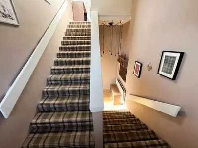 a staircase in a home with a carpeted stair case at A Spacious Flat with Character - Private Car Space in Paisley