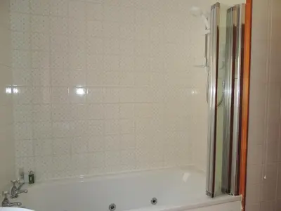 a bathroom with a bath tub and a sink at Atlantic Bay Cottage in Clachan