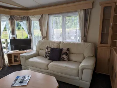 a living room with a couch and a tv at The Senator 69 in Dunoon