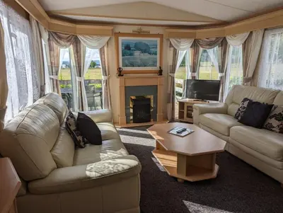 a living room with two couches and a fireplace at The Senator 69 in Dunoon