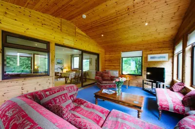 a living room with red couches and a tv at The Buzzard Lodge 2 bedroom sleeps up to 4 in Crianlarich