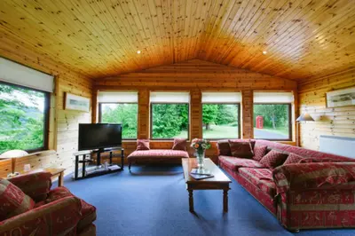 a living room with couches and a flat screen tv at The Buzzard Lodge 2 bedroom sleeps up to 4 in Crianlarich