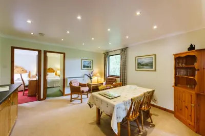 a living room with a table and a bedroom at The Buzzard Lodge 2 bedroom sleeps up to 4 in Crianlarich