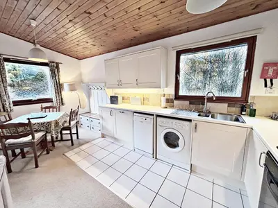 a kitchen with a sink and a washing machine at Fisher Lodge sleeps up to 2 in Crianlarich