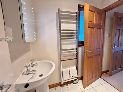 a bathroom with a sink and a toilet and a mirror at Fisher Lodge sleeps up to 2 in Crianlarich