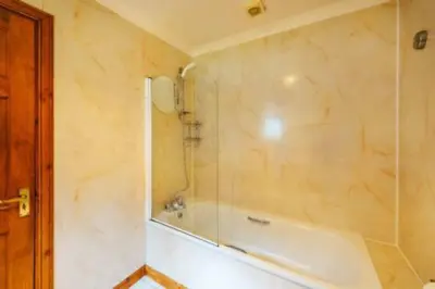 a bathroom with a shower and a bath tub at Fisher Lodge sleeps up to 2 in Crianlarich