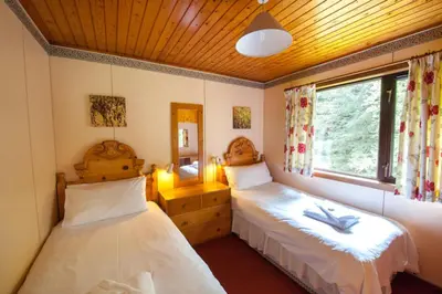 a bedroom with two beds and a window at Heron Lodge sleeps up to 4 with free wifi in Crianlarich