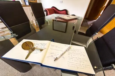 a book with a key on top of it on a table at Kingfisher Lodge with sensational loch views in Crianlarich