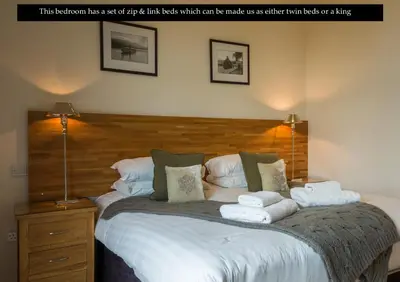 a bedroom with a large bed with towels on it at Mains of Taymouth Country Estate 5* Maxwell Villas in Kenmore