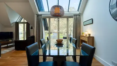 a dining room with a glass table and chairs at Mains of Taymouth Country Estate 4* Houses in Kenmore