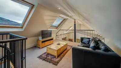 a living room with a couch and a tv at Mains of Taymouth Country Estate 5* Houses in Kenmore