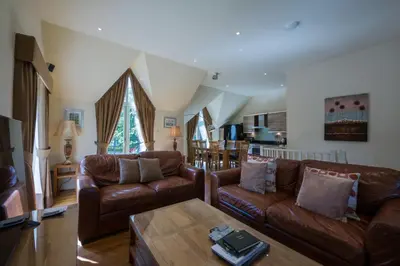 a living room with leather couches and a table at Mains of Taymouth Country Estate 5* Houses in Kenmore