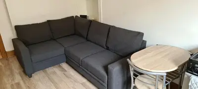 a gray couch in a living room with a table at Rozina Apartment in Paisley