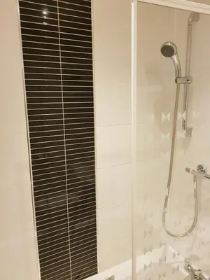 a shower with a glass door in a bathroom at Rozina Apartment in Paisley