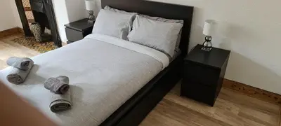 a bed with two pillows and towels on it at Rozina Apartment in Paisley