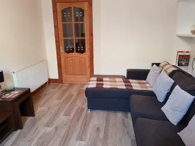 a living room with a couch and a table at Rozina Apartment in Paisley