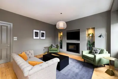 a living room with a couch and two chairs at JOIVY Luxury Home on George Street in Edinburgh