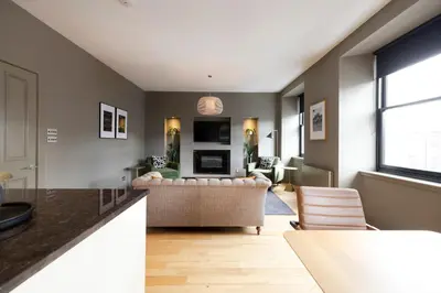 a living room with a couch and a table at JOIVY Luxury Home on George Street in Edinburgh