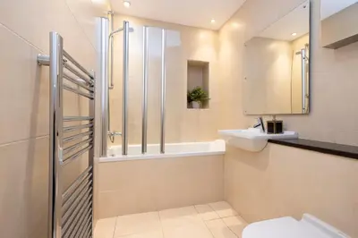 a bathroom with a shower and a sink and a toilet at JOIVY Luxury Home on George Street in Edinburgh