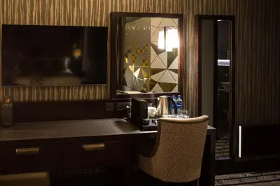a hotel room with a desk with a chair and a mirror at Mondo Hotel in Coatbridge