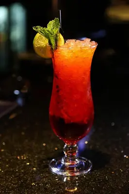 a red drink in a glass with a lime on it at Mondo Hotel in Coatbridge