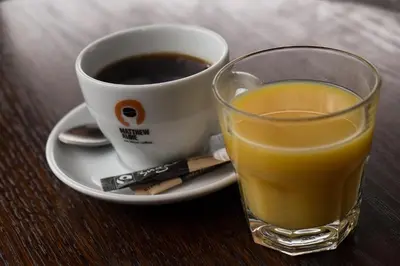 a glass of orange juice next to a cup of coffee at Mondo Hotel in Coatbridge