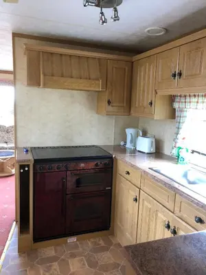 a kitchen with wooden cabinets and a stove top oven at 35 Glenfinart Park in Dunoon