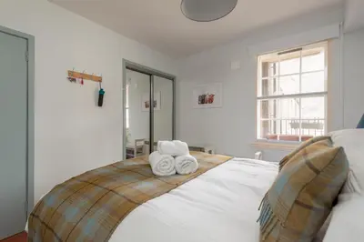 a bedroom with a bed with two towels on it at The Wee Highland Coo in Edinburgh