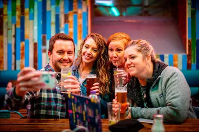 a group of people sitting at a table drinking beer at Kick Ass Grassmarket (18+) in Edinburgh