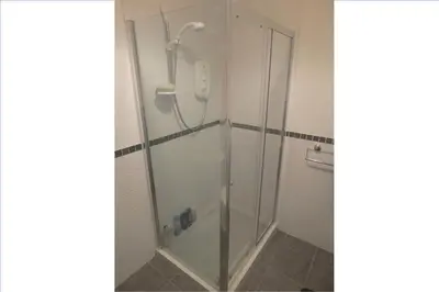 a shower with a glass door in a bathroom at Trefoil Holiday Home in Strachur
