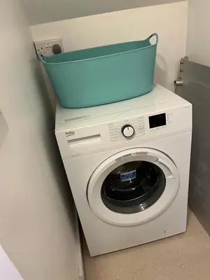 a washing machine with a blue basket on top of it at Pottery Cottage, Lochans Lodge in Stranraer