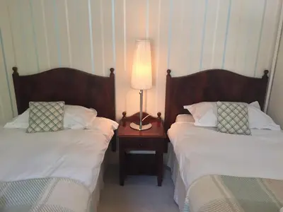 a bedroom with two beds and a lamp on a night stand at Glenburnie House in Oban