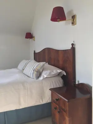 a bedroom with a bed with two lamps and a table at Glenburnie House in Oban