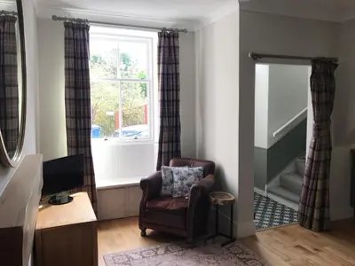 a living room with a chair and a window at The Cottage in Dunblane