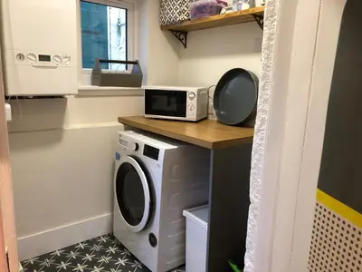 a kitchen with a microwave and a washing machine at The Cottage in Dunblane