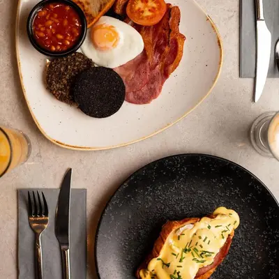 a plate of breakfast food with eggs bacon and beans at Royal Hotel in Cumnock
